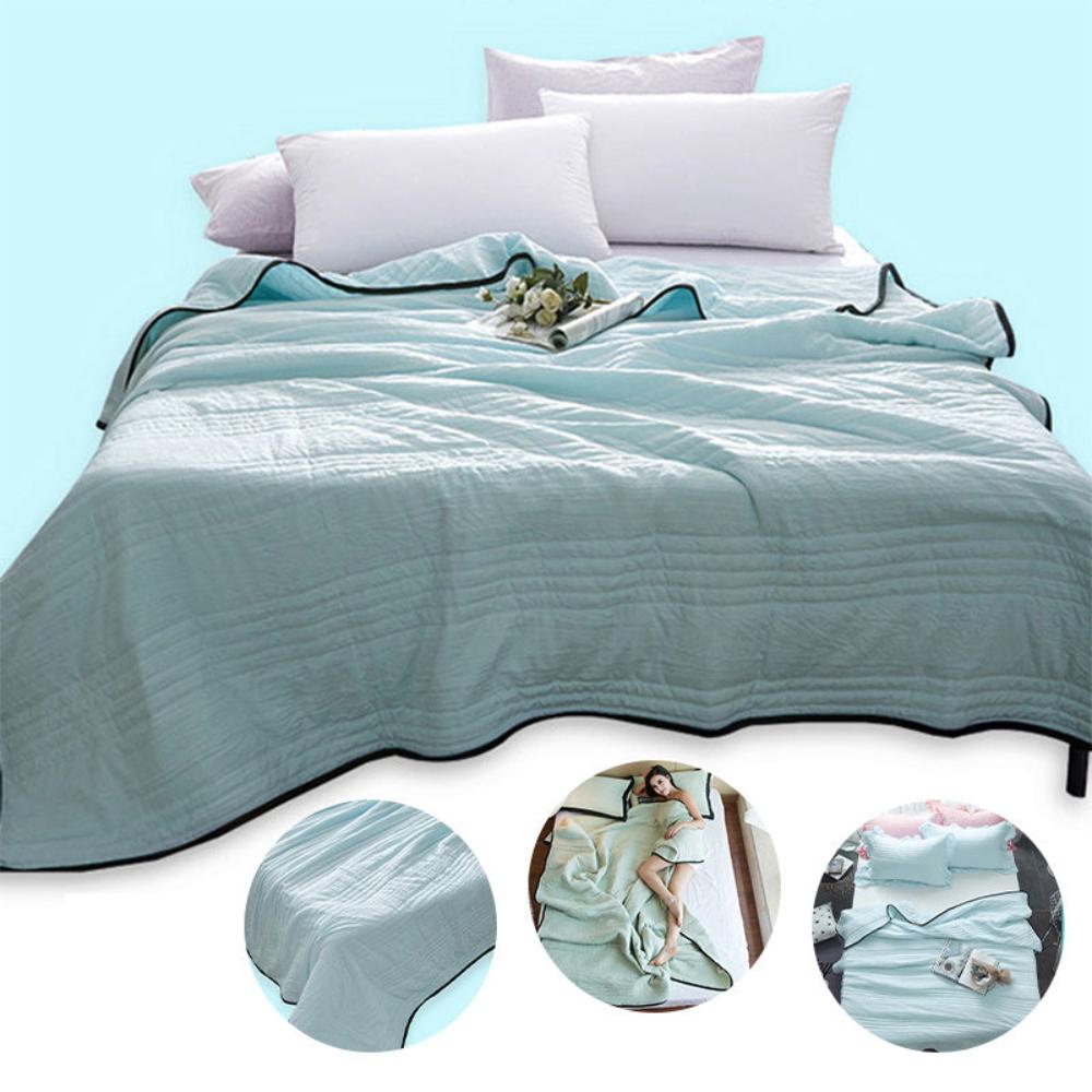 The cooling blanket in water green. Three graphics of the beds corner, a woman lying on the bed and a bed with the blanket slightly pulled back.